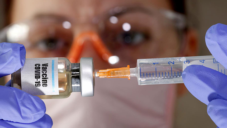 A woman holds a small bottle labeled with a "Vaccine COVID-19" sticker and a medical syringe in this photo illustration. (CNS photo/Dado Ruvic, Reuters)