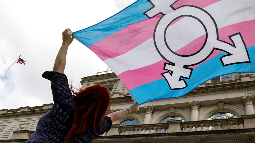 A person in New York City holds up a flag Oct. 24, 2018, to protest a policy by the then-Trump administration to define sex as an individual's status as male or female based on traits identified at birth. (CNS photo/Brendan McDermid, Reuters)